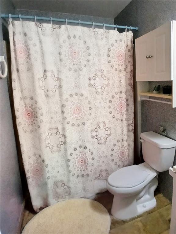 242 Lake Jodeco Road, Unit 242 Jonesboro, GA 30236 - Photo 43 of 45 a white toilet sitting next to a shower curtain