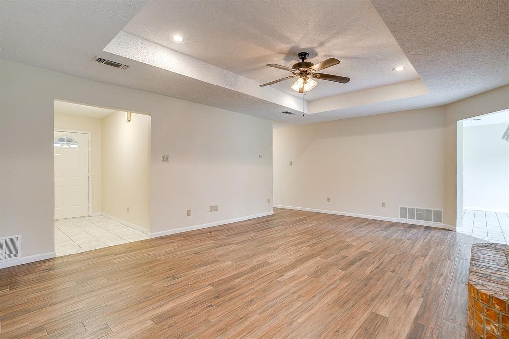 8613 Silver Creek Road White Settlement, TX 76108 - Photo 8 of 40 a view of an empty room with wooden floor and a ceiling fan