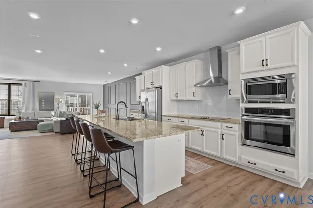 a large kitchen with kitchen island a large counter top space and stainless steel appliances