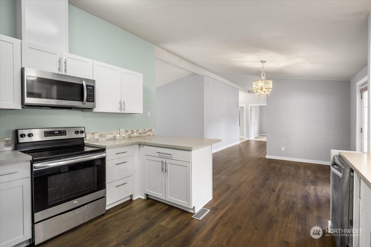 815 Carlson Road Snohomish, WA 98290 - Photo 6 of 21 a kitchen with stainless steel appliances white cabinets a sink and a stove