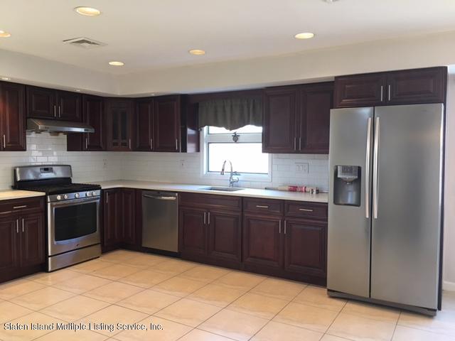 50 Beacon Place Staten Island, NY 10306 - Photo 14 of 28 a kitchen with a refrigerator sink and wooden cabinets