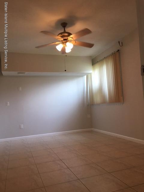 50 Beacon Place Staten Island, NY 10306 - Photo 19 of 28 en empty room with window and chandelier fan