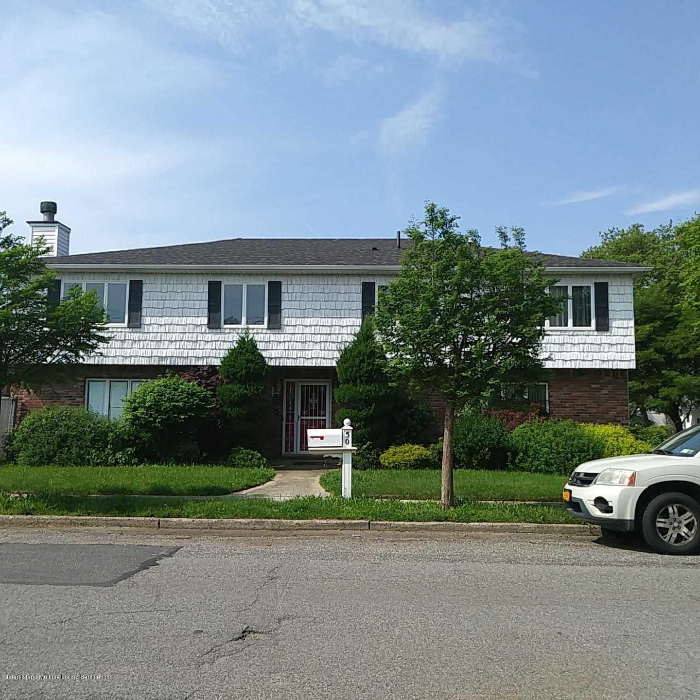 50 Beacon Place Staten Island, NY 10306 - Photo 2 of 28 a front view of a house with a yard and garage
