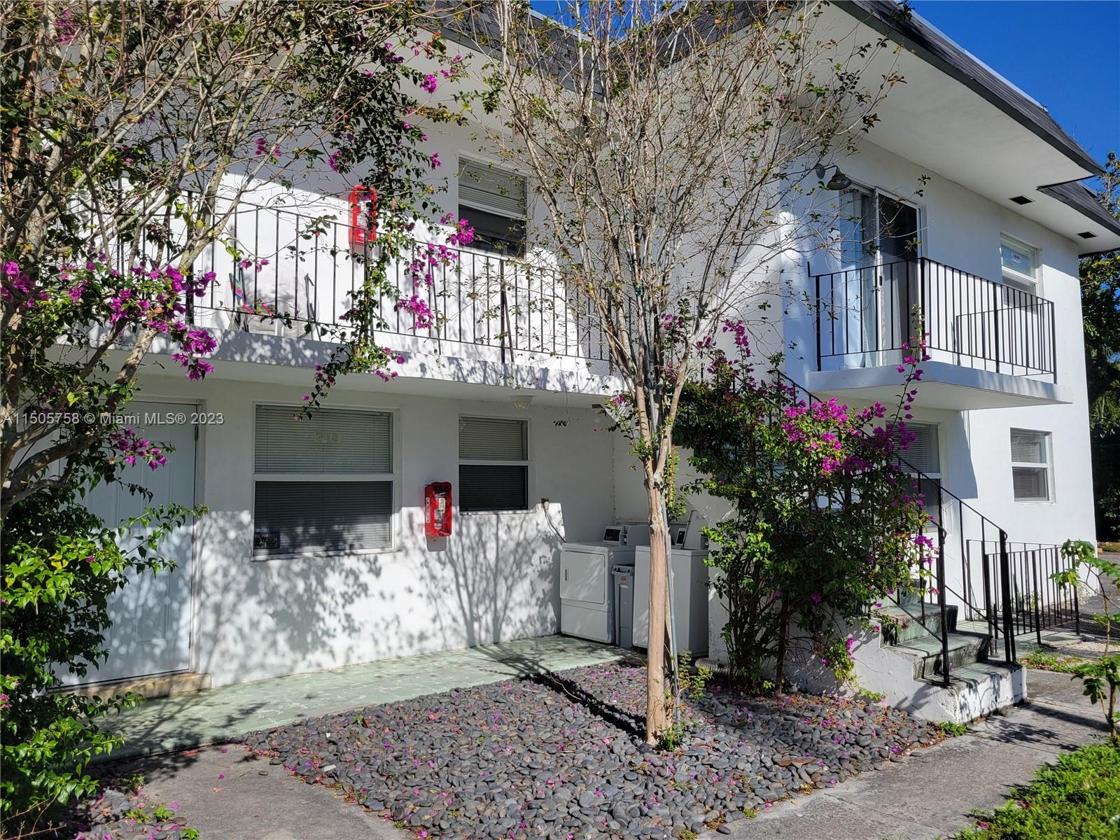 a front view of a house with a tree