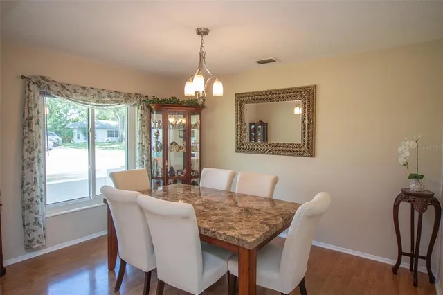 a dining room with furniture a chandelier and wooden floor