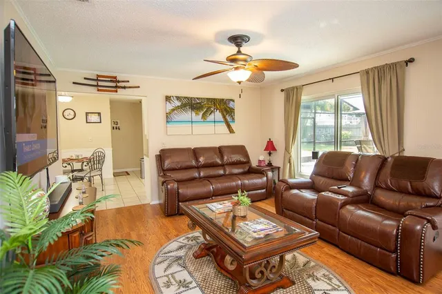 a living room with furniture a ceiling fan and a window