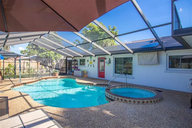 a view of a backyard with table and chairs under an umbrella
