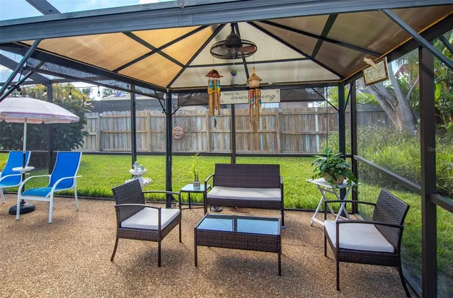 a view of a patio with a table and chairs under an umbrella