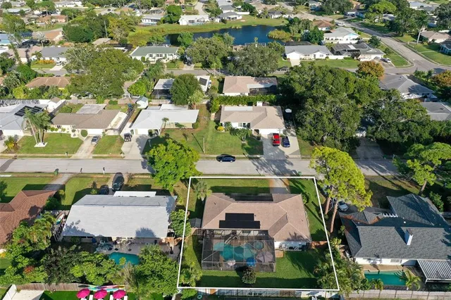 an aerial view of residential houses with outdoor space and parking