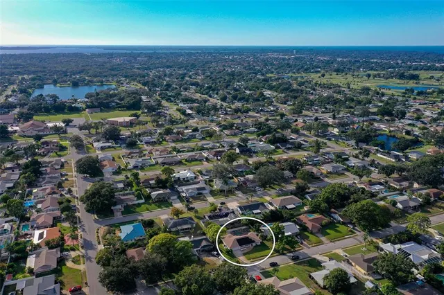 an aerial view of residential house with parking and yard