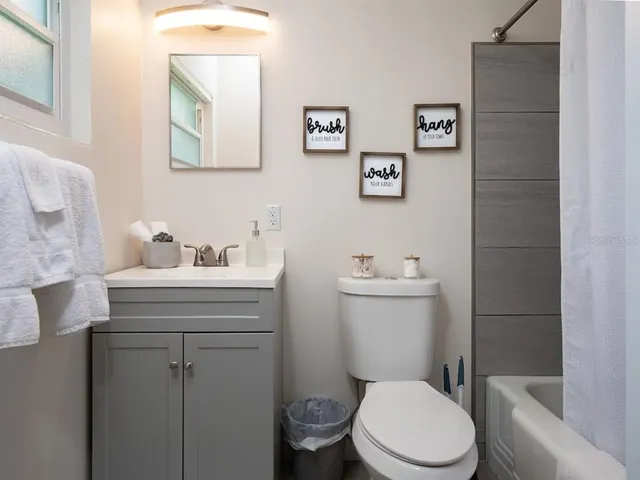 a bathroom with a sink mirror and toilet