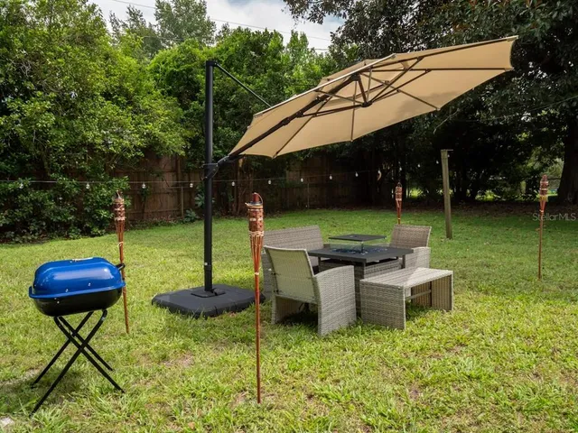 a backyard of a house with table and chairs