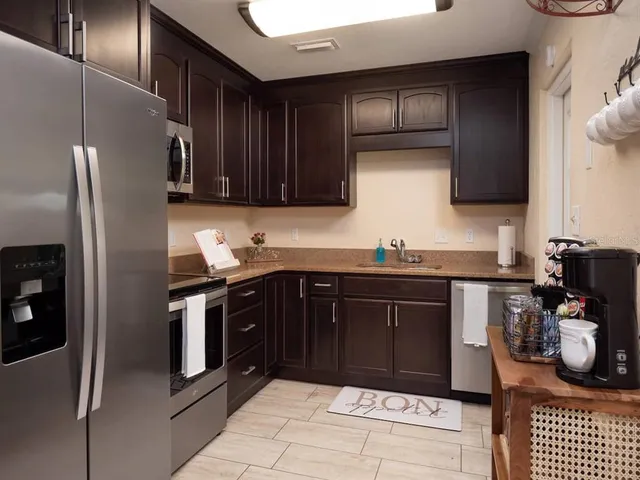 a kitchen with stainless steel appliances granite countertop a refrigerator and a sink