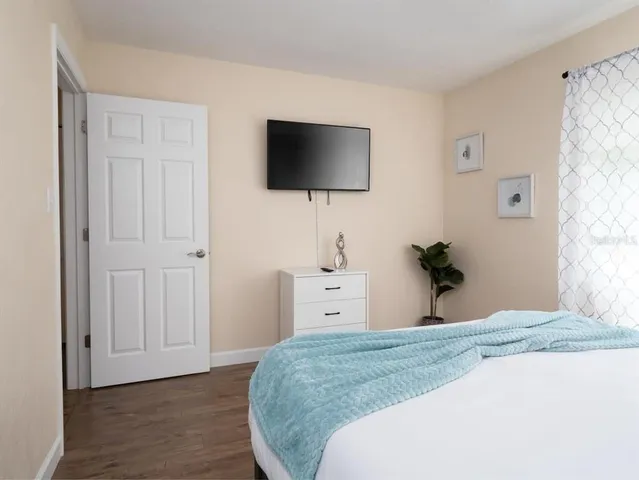 a bedroom with a bed and a flat screen tv