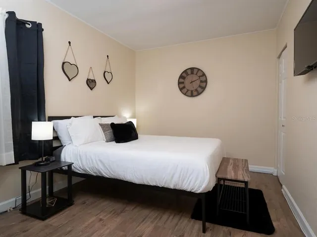 a bedroom with a bed and a lamp on dresser
