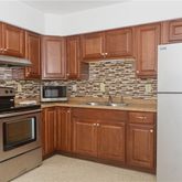 a kitchen with stainless steel appliances granite countertop a refrigerator and a stove top oven