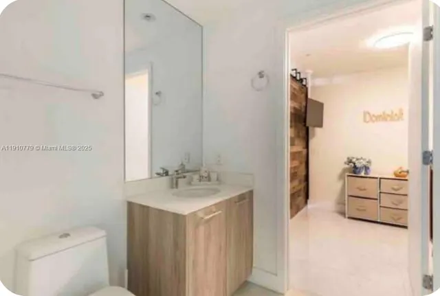 a view of a hallway with a livingroom and a bathroom