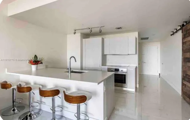 a kitchen with granite countertop a sink and cabinets