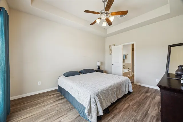 a bedroom with a bed and a flat tv screen on a dresser