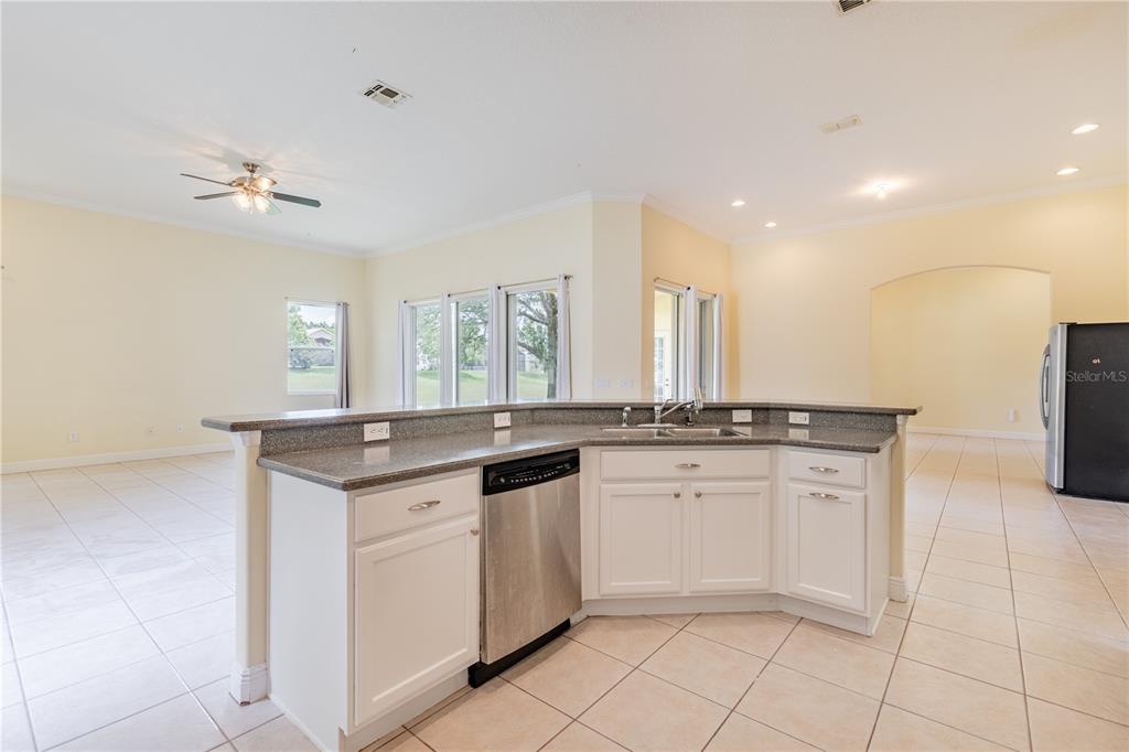 2718 Knightsbridge Road Clermont, FL 34711 - Photo 36 of 72 a kitchen with granite countertop white cabinets and white appliances