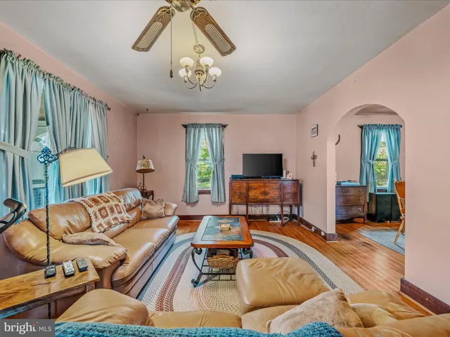 a living room with furniture a flat screen tv and a large window