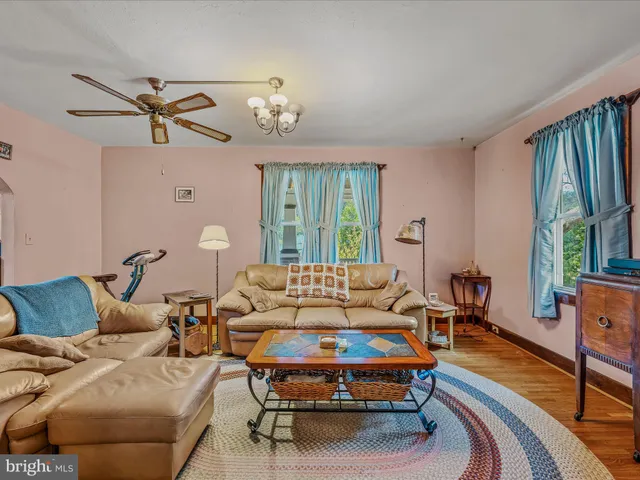 a living room with furniture a large window and a chandelier