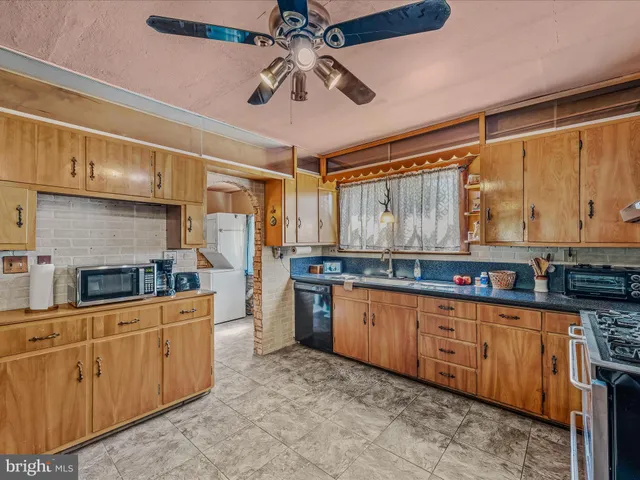 a kitchen with stainless steel appliances granite countertop a sink window and cabinets
