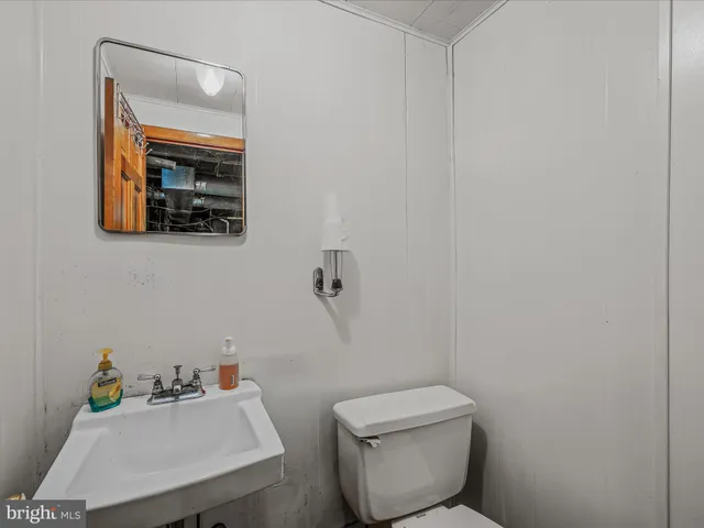 a bathroom with a toilet sink and mirror