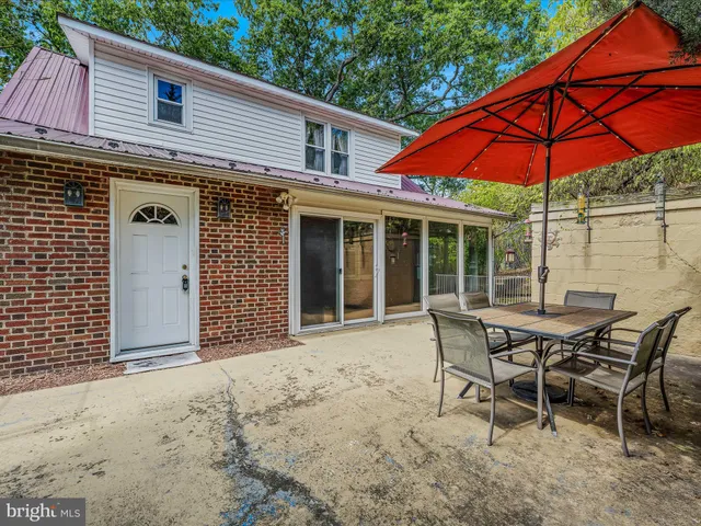a patio with a table and chairs under an umbrella