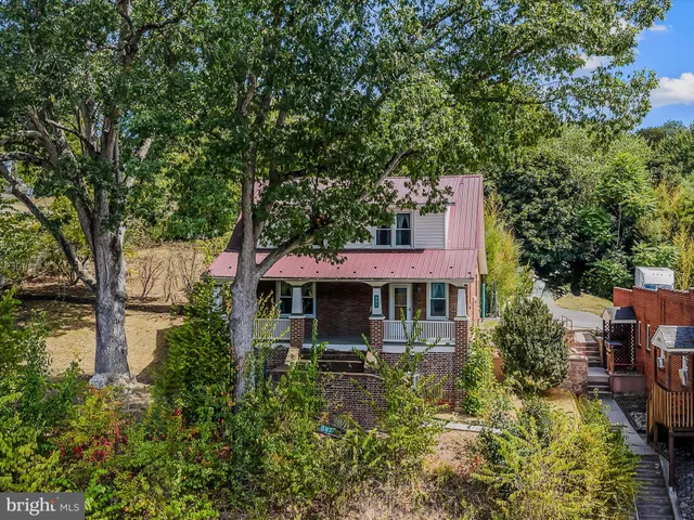 a front view of a house with a yard and large trees