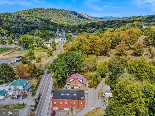 an aerial view of residential houses with outdoor space and trees