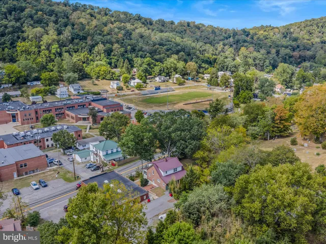 an aerial view of residential house with outdoor space and trees all around