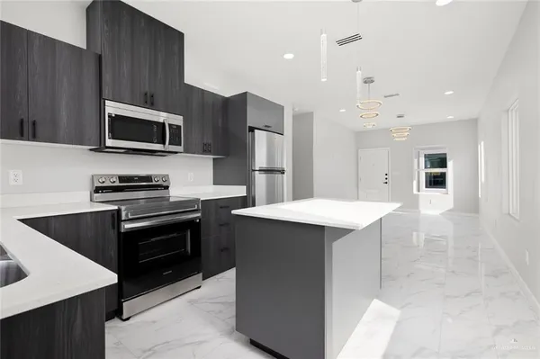 a kitchen that has a sink stainless steel appliances and cabinets