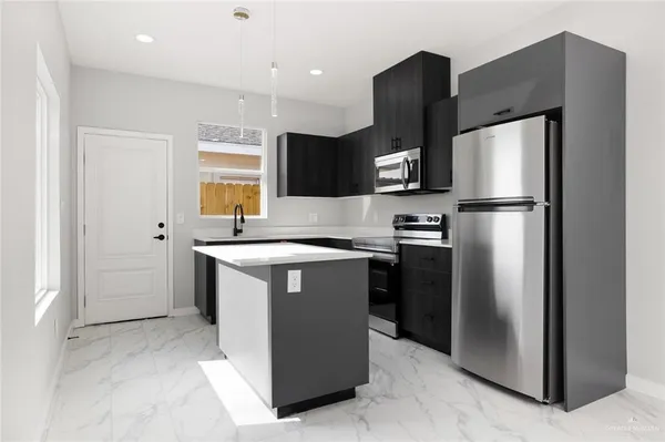 a kitchen with stainless steel appliances granite countertop a refrigerator and a sink