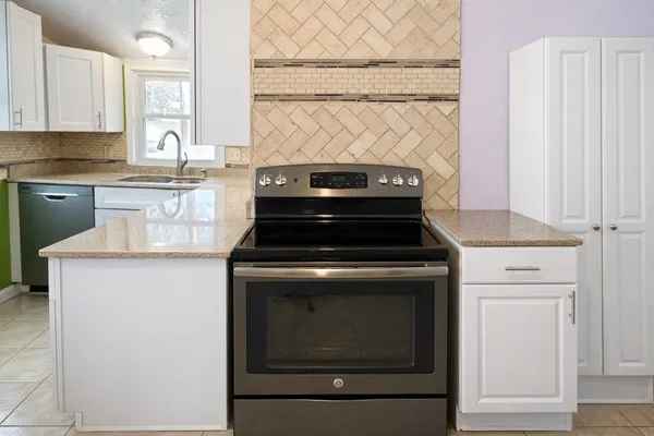 a stove top oven sitting inside of a kitchen