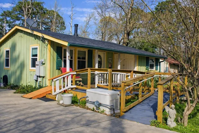 a view of wooden house with large windows and a wooden deck