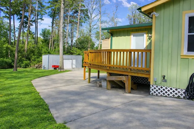 a view of a chair and table in backyard of the house