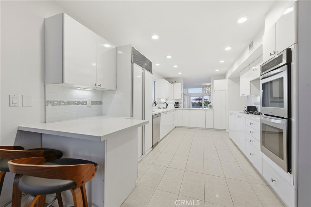 12815 Via Nestore Del Mar, CA 92014 - Photo 13 of 42 a kitchen with white cabinets and stainless steel appliances