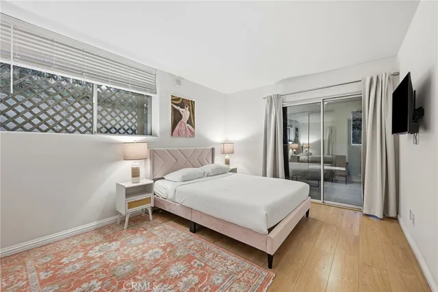 a bedroom with a bed and a flat tv screen on dresser