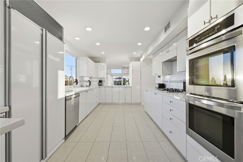 12815 Via Nestore Del Mar, CA 92014 - Photo 10 of 42 a kitchen with white cabinets and stainless steel appliances