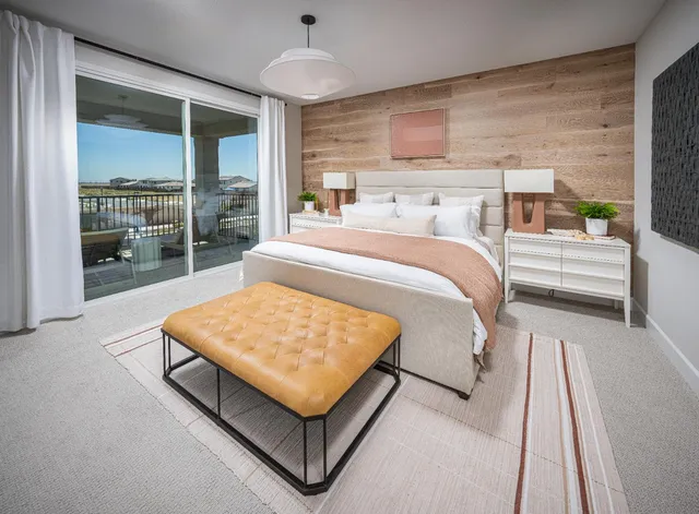 a bed sitting in a spacious bedroom next to a window