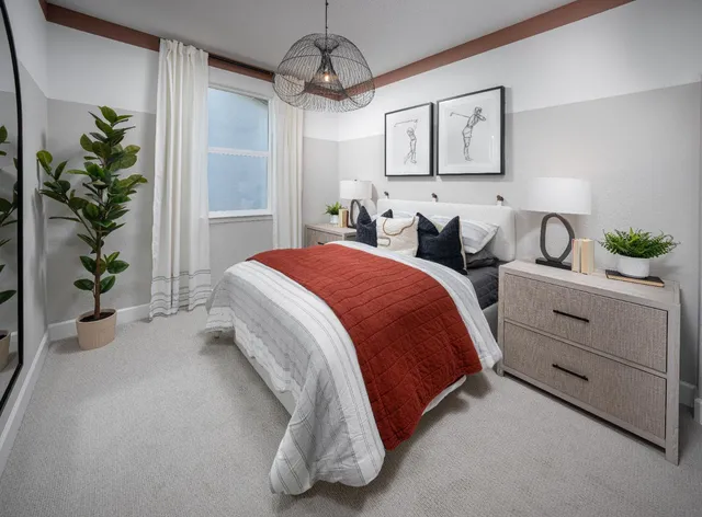 a spacious bedroom with a bed and a potted plant