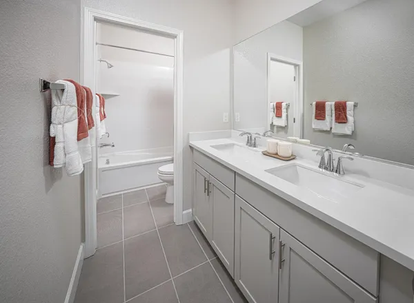 a spacious bathroom with a double vanity sink toilet and shower
