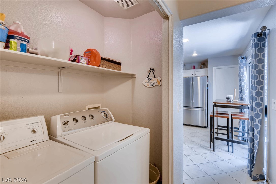 10451 Processor Court Las Vegas, NV 89129 - Photo 24 of 28 Functional laundry nook features stacked machines and ample shelving for household necessities.