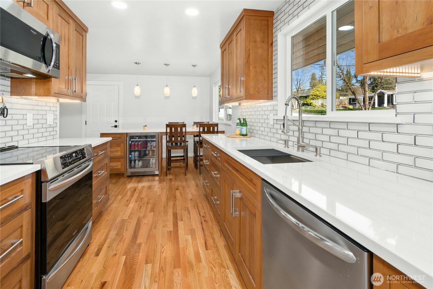 24022 4th Place West Bothell, WA 98021 - Photo 7 of 36 a kitchen with stainless steel appliances granite countertop a sink a stove top oven a chimney cabinets and a dining table