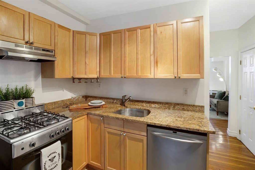 60 Myrtle Street, Unit 1 Boston, MA 02114 - Photo 2 of 14 a kitchen with stainless steel appliances granite countertop a sink stove and cabinets