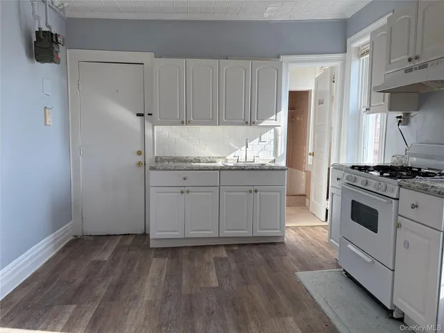 a kitchen with granite countertop a sink and a stove top oven