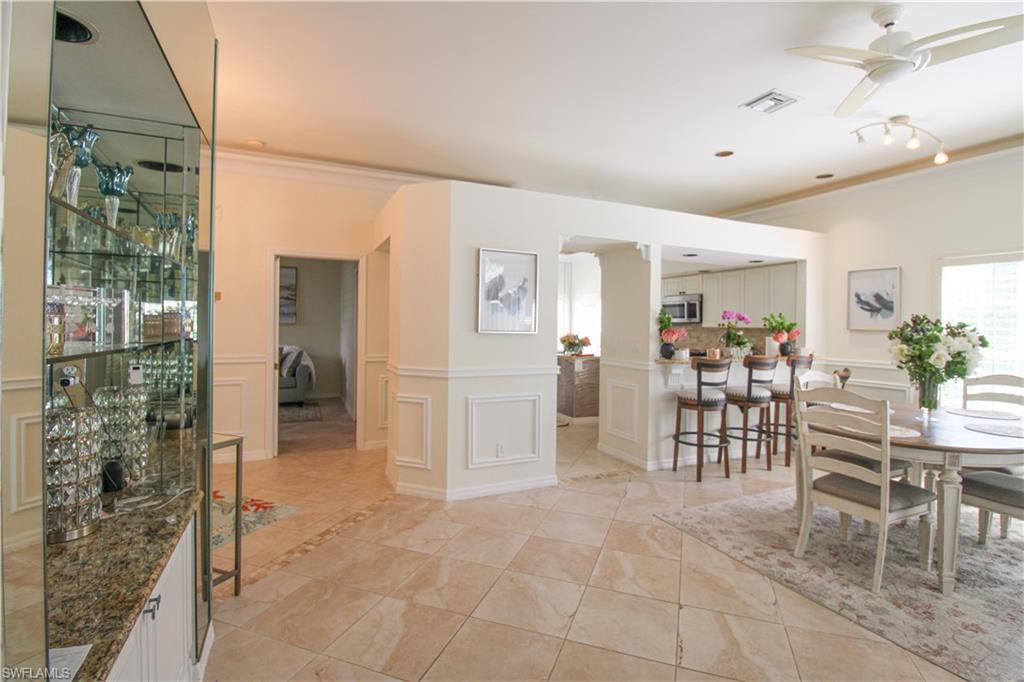 152 Napa Ridge Way Naples, FL 34119 - Photo 17 of 50 a view of a kitchen with dining area windows and chairs