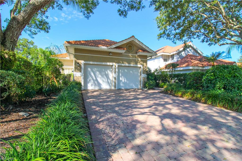 152 Napa Ridge Way Naples, FL 34119 - Photo 2 of 50 a view of a house with a small yard and a large tree
