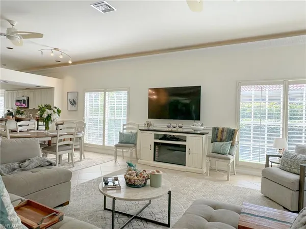 a living room with furniture a flat screen tv and a large window